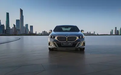 BMW 5 Series front view against a city skyline