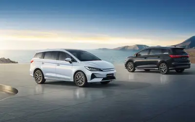 BYD eMAX 7 front and rear three-quarter views, white and black cars side by side