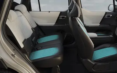 Kia Syros EV cabin with front and rear seats in black and teal upholstery