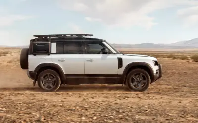 Land Rover Defender 110 side profile on a desert track in white