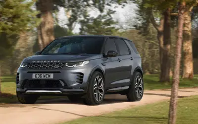 Land Rover Discovery Sport front three-quarter view on a tree-lined road