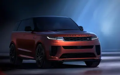 Range Rover Sport front three-quarter view under dramatic studio lighting in red