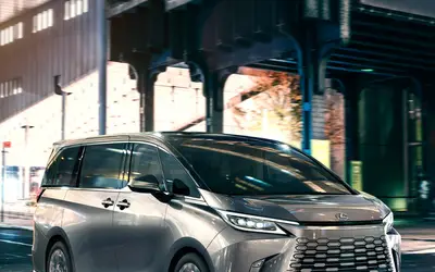 Lexus LM front three-quarter view at night under an overpass