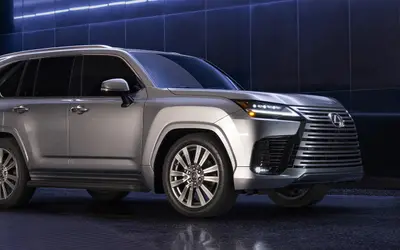 Lexus LX front three-quarter view in silver against a dark blue backdrop