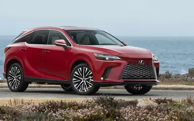 Lexus RX front three-quarter view in red on a coastal road