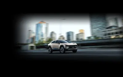 Mahindra BE 6 front three-quarter view driving through a city