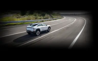 Mahindra BE 6 rear three-quarter view driving on a highway