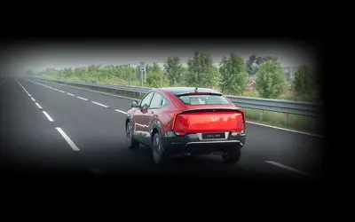 Mahindra XEV 9e rear view in red on a highway