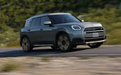 MINI Countryman Electric in blue-grey on the move, front three-quarter view
