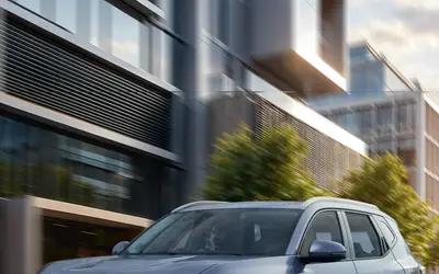 Nissan Tekton front three-quarter view in grey driving through a city