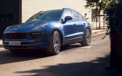 Porsche Macan in blue on the move, front three-quarter view