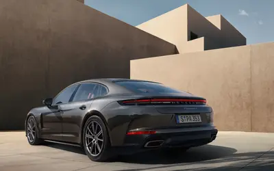 Porsche Panamera rear three-quarter view in grey against sand-coloured architecture