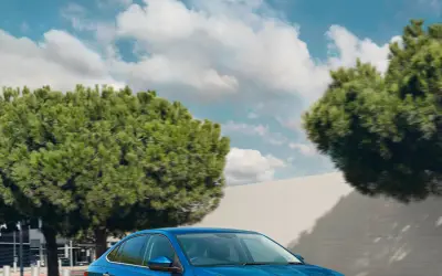 Skoda Slavia front view in blue driving on a city street