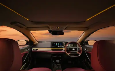 Tata Curvv dashboard with ambient lighting, burgundy cabin and panoramic sunroof