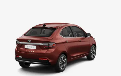 Tata Tigor rear three-quarter view from the opposite side in Classy Red