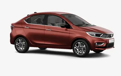 Tata Tigor front three-quarter view from the passenger side in Classy Red