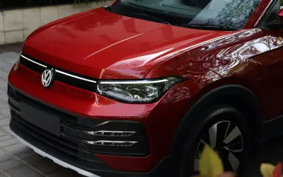 Volkswagen Taigun front-end close-up in red showing LED light bar and headlights