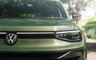 Volkswagen Taigun front grille close-up in green with illuminated LED strip and VW logo