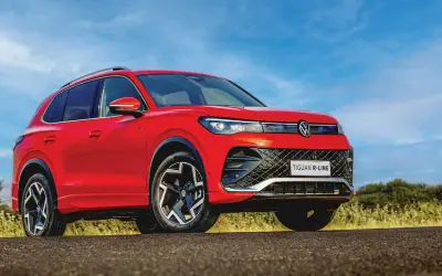Volkswagen Tiguan R-Line low-angle front three-quarter view in red against a blue sky
