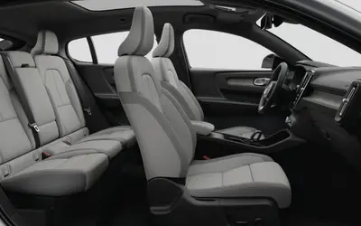 Volvo EC40 cabin seen from the side, front and rear seats in light upholstery