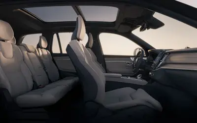 Volvo XC90 cabin seen from the side, showing all three seat rows in light upholstery